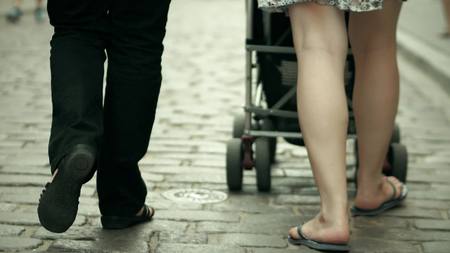 Family walk with the baby stroller on cobblestone pavementの写真素材