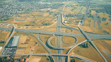 Aerial shot of modern highway interchange in outskirts on an autumn sunny day