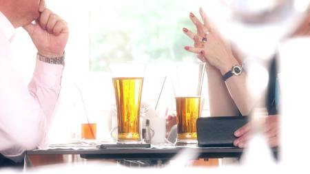 Colleagues having table conversation at the restaurantの写真素材