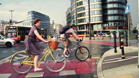 WARSAW, POLAND - JULY 11, 2017. Young woman riding her classic bicycle in the city. Modern urban street trafficのeditorial素材