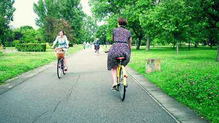 WARSAW, POLAND - JULY 11, 2017. Women cycling along park road