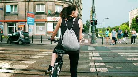 WARSAW, POLAND - JULY 11, 2017. Young athletic female cyclist waiting at the city street crosswalkのeditorial素材