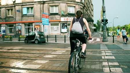 WARSAW, POLAND - JULY 11, 2017. Young athletic woman cycling along the city street crosswalkのeditorial素材