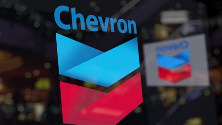 Chevron Corporation logo on the glass against blurred business center. Editorial 3D renderingのeditorial素材