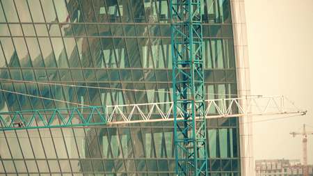 Tower cranes at a modern office skyscraper construction site
