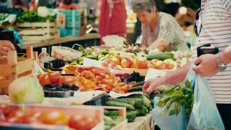 PULA, CROATIA - AUGUST 4, 2017. Man buying cucumbers at local marketplaceのeditorial素材