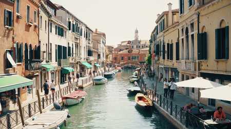 VENICE, ITALY - AUGUST 8, 2017. Tourists walk along Venetian canalのeditorial素材
