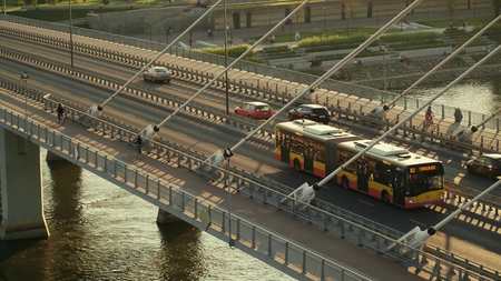 WARSAW, POLAND - AUGUST 30, 2017. Aerial shot of a city bus moving along modern guyed bridge over...