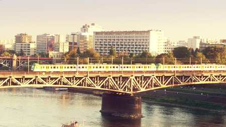 WARSAW, POLAND - AUGUST 30, 2017. Aerial shot of an electric train moving on the railroad bridge over the Vistula river in the eveningのeditorial素材