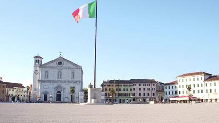 PALMANOVA, ITALY - AUGUST 11, 2017. Central city square and waving Italian flagのeditorial素材