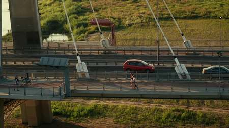 Aerial shot of cyclists, pedestrian and cars moving along modern guyed bridge over the Vistula riverの写真素材