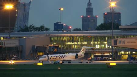 WARSAW, POLAND - SEPTEMBER 14, 2017. Adria Airways commercial airplane at the international Chopin airport terminal at nightのeditorial素材