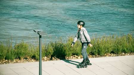 WARSAW, POLAND - SEPTEMBER 28, 2017. Roller skater boy riding along the park embankment