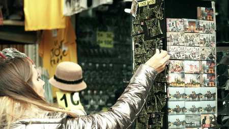 PARIS, FRANCE - OCTOBER 7, 2017. Young woman buying the Eiffel tower souvenir magnet in a tourist placeのeditorial素材
