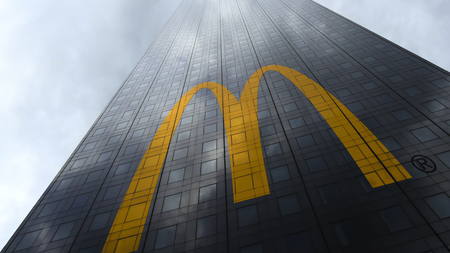 McDonalds logo on a skyscraper facade reflecting clouds. Editorial 3D rendering
