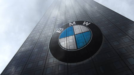 BMW logo on a skyscraper facade reflecting clouds. Editorial 3D rendering