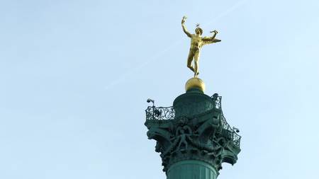 Distant commercial airplane leaving vapor trail in the sky behind ancient monument in Paris, Franceの写真素材