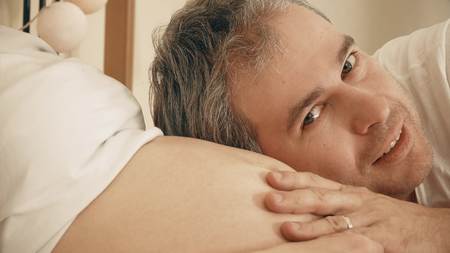 Handsome man stroking pregnant wifes belly