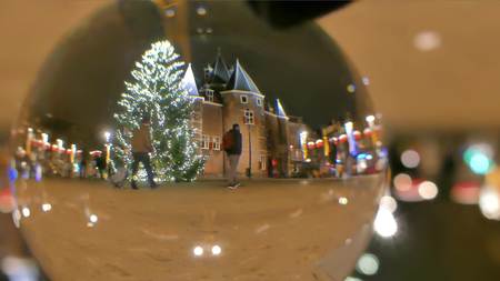 Big decorated Christmas tree in the evening, view through the glass ball. Amsterdam, Netherlandsの写真素材