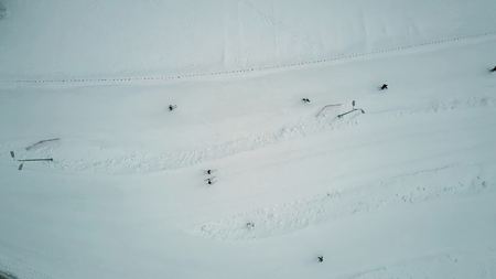 Aerial top down view of people skiing down the mountain slope