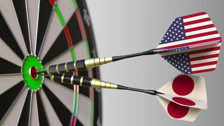 Flags of the USA and Japan on darts hitting bullseye of the target. International cooperation or competition conceptual 3D renderingの写真素材