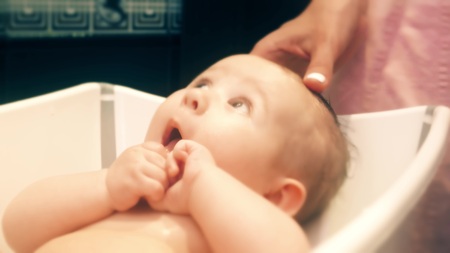 Mom washing baby girl hair
