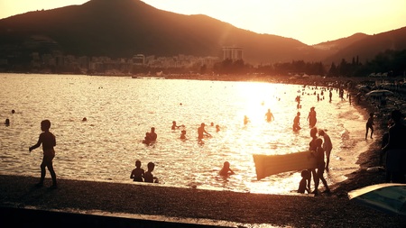 Silhouettes of people on the beach at sunset
