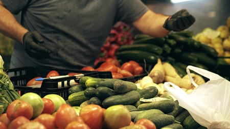 Unknown vendor and customer at vegetable stall in famous Mercado Central