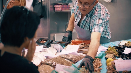 VALENCIA, SPAIN - SEPTEMBER 22, 2018. Customer and vendor at seafood stall in famous Mercado Central or Central Marketのeditorial素材