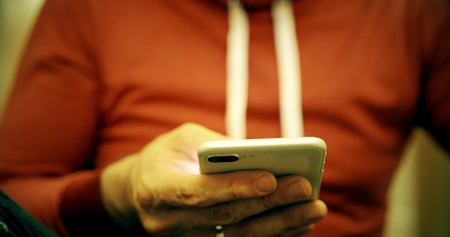 Man in red casual clothes uses his smartphoneの写真素材