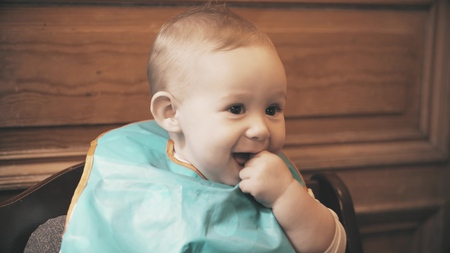 Baby girl wearing bib smiles, close-upの写真素材