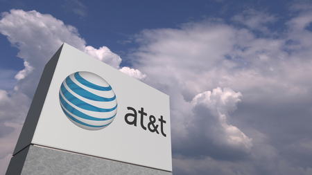 Logo of AT&T on a stand against cloudy sky, editorial 3D renderingのeditorial素材
