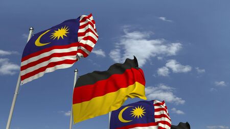 Flags of Malaysia and Germany against blue sky, 3D renderingの写真素材