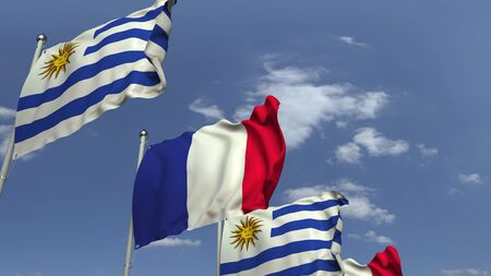 Flags of Uruguay and France against blue sky, 3D renderingの写真素材