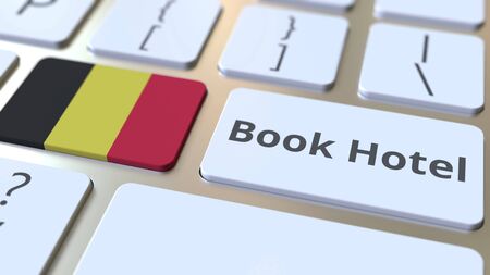 BOOK HOTEL text and flag of Belgium on the buttons on the computer keyboard. Travel related conceptual 3D renderingの写真素材