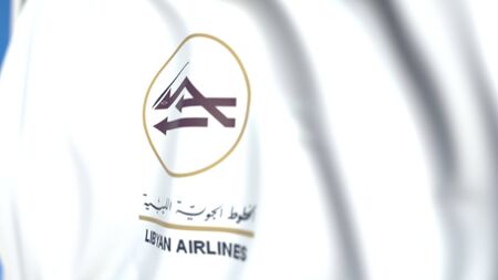 Flying flag with Libyan Airlines logo, close-up. Editorial 3D renderingのeditorial素材