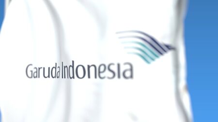 Waving flag with Garuda Indonesia logo, close-up. Editorial 3D rendering