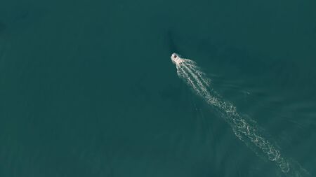 Aerial top down shot of a moving motorboat