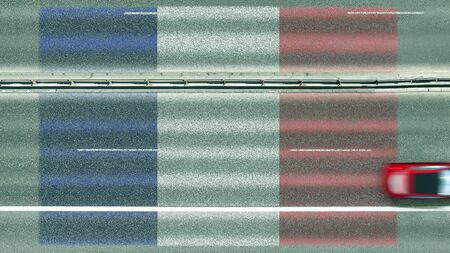 Aerial top down view of car and flag of France on the road. Traveling related conceptual 3D...