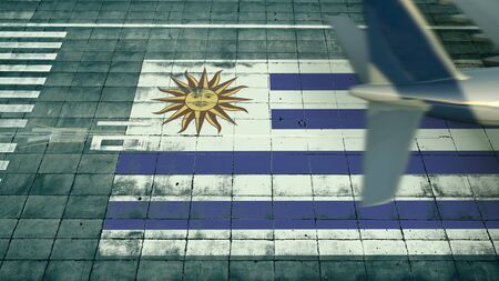 Aerial view of a landing airplane and flag of Uruguay on the airfield of an airport. Air travel related conceptual 3D renderingの写真素材