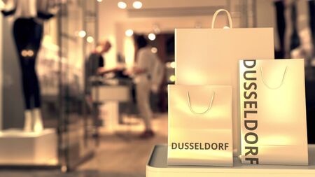Shopping bags with Dusseldorf caption against blurred store entrance. Shopping in Germany related...