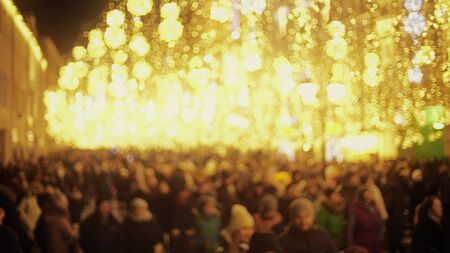 Crowded pedestrian street in city centre decorated for New Year and Christmasの写真素材