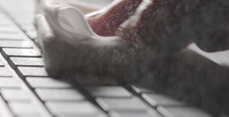 Alcohol disinfectant spraying and wiping to sanitize the keyboard. Workplace hygiene during coronavirus outbreakの写真素材