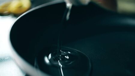 Pouring sunflower oil in non-stick frying panの写真素材