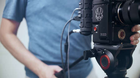 MOSCOW, RUSSIA - JULY 13, 2020. Man operating RED DRAGON professional cinema camera mounted on a tripodの写真素材