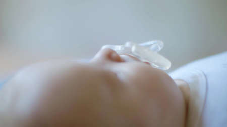 Unknown newborn baby with pacifier close-up
