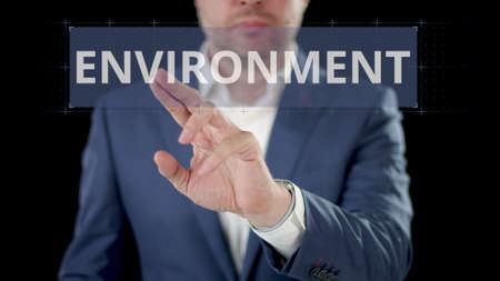 Businessman scrolls to ENVIRONMENT digital option on the modern touchscreen display