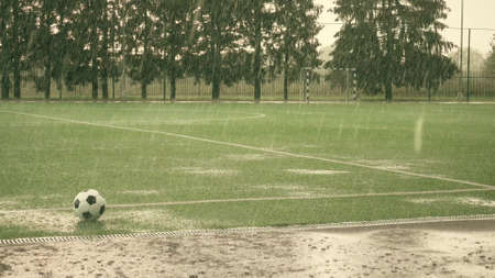 Artificial grass football field. Stopped match in heavy rain