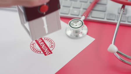 Putting MEDICAL WARNING stamp on the paper