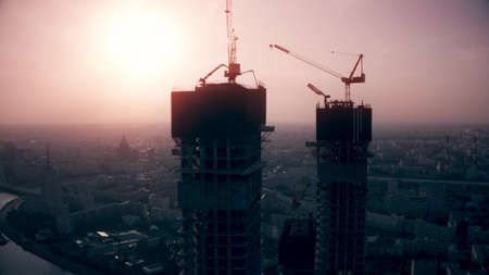 Aerial shot of modern skyscrapers under construction, silhouettes of the buildings on the morning sky background. Moscow, Russiaの写真素材
